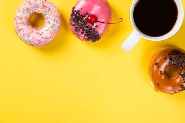 istock Cup with coffee and donuts on yellow background. Top view and free space for your text 685680244