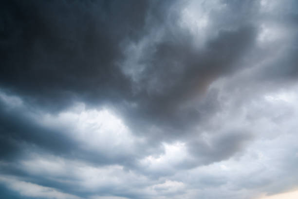 istock black sky Background of dark clouds before a thunder. sunlight through very dark clouds background of dark storm clouds 685690052