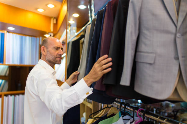 istock Man looking a suit jackets on a rack in a tailors shop 685690302