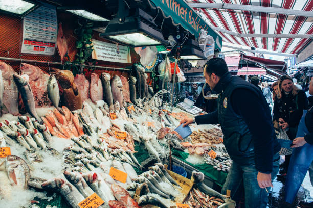 People buying fresh fish on the market in Kadıkoy Istanbul: People buying fresh fish on the market in Kadıkoy, Istanbul. Man trading on turkish bazaar. costus stock pictures, royalty-free photos & images