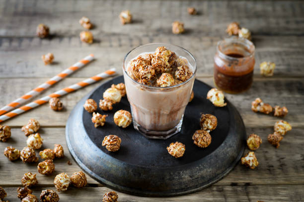 Popcorn, confectionery and drink on wooden table with 4th july theme