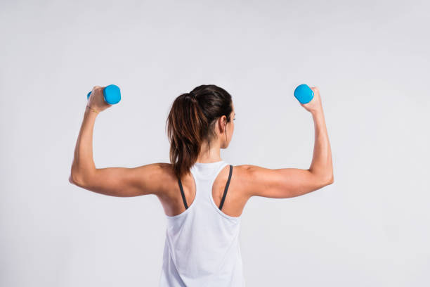 멍 청이 들고 매력적인 젊은 피트 니스 여자. 스튜디오 촬영. - dumbbell women body building exercises flexing muscles 뉴스 사진 이미지