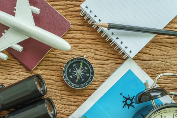istock Travel planning concept with airplane, passport, compass, binoculars, pencil and paper note on wood table 685752490