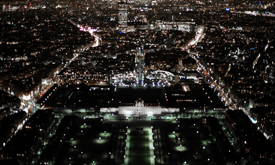 Looking down from the top of the Eiffel Tower across Paris at night.