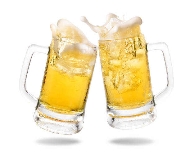 Cheering beer Cheers cold beer with splashing out of glasses on white background. beer glass splash stock pictures, royalty-free photos & images