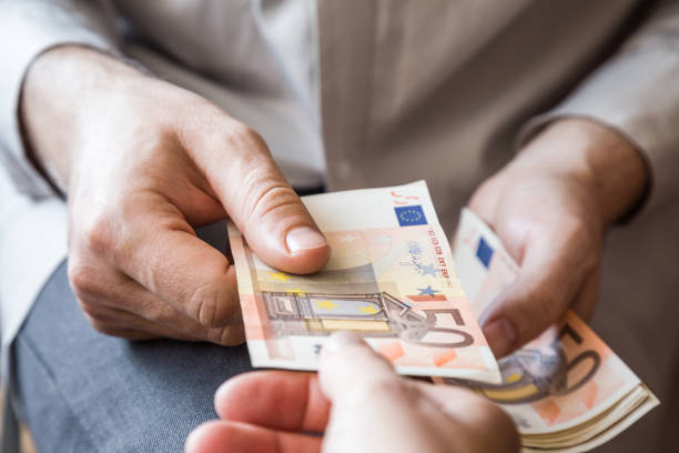 istock Man's hand giving a money. Dealing with euro banknotes. 685762680