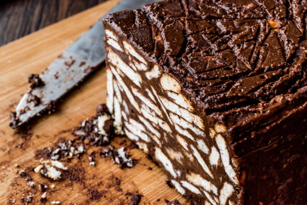木の表面にナイフでチョコレートとビスケット ケーキをモザイクします。 - plate ingredient food chocolate ストックフォトと画像