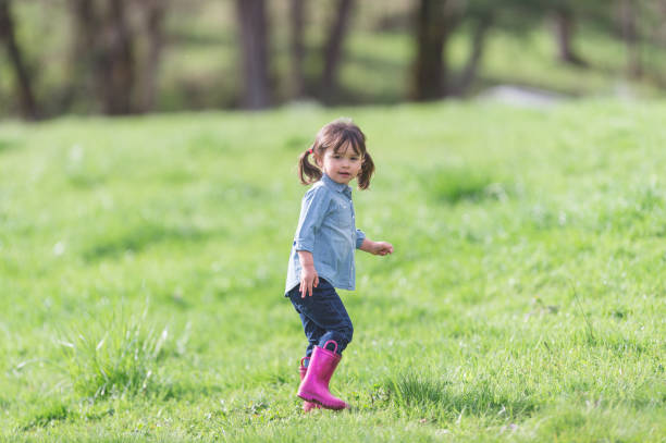 istock Young ethnic girl walking in pasture with cute boots 685771928