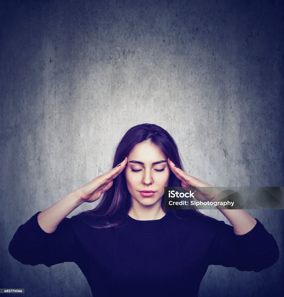 Stressed anxious woman with headache Stressed anxious woman with headache isolated on gray grunge wall background Emotional Stress Stock Photo