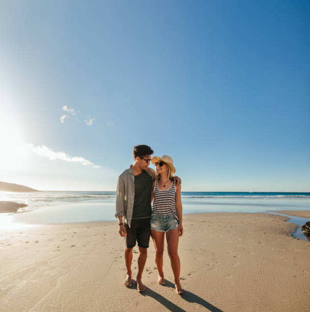 istock Romantic young couple walking on sea shore 685775650