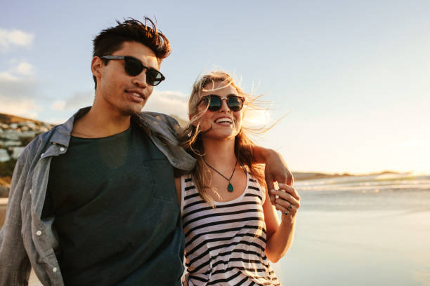 young couple enjoying a summer day on seashore - clothing casual concepts love imagens e fotografias de stock