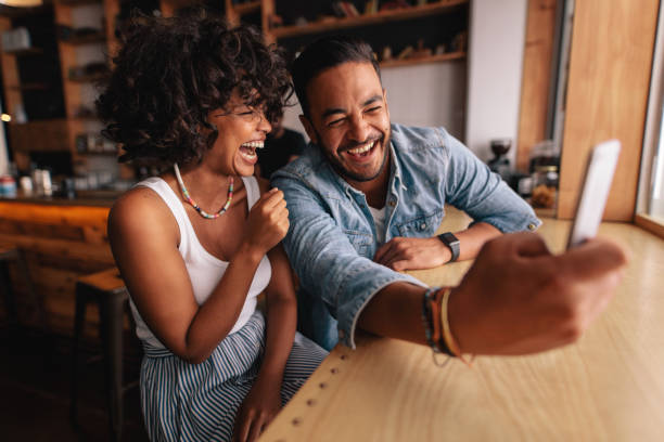 istock Laughing couple taking selfie at coffee shop 685776288