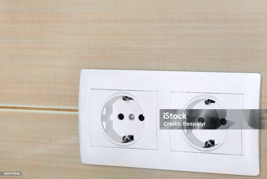 the electric socket of 220v. the electric socket of 220 volts, the double socket from white plastic established on a working zone from a ceramic tile. Domestic Kitchen Stock Photo