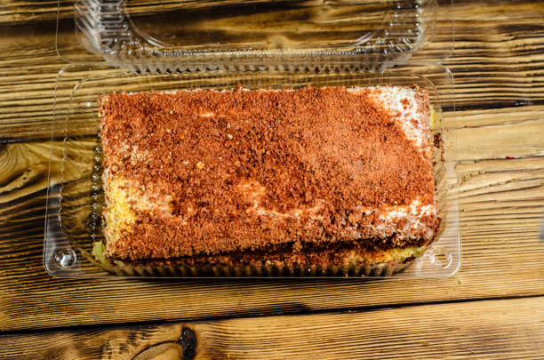 istock Biscuit cake in plastic container on wooden table. Top view 685779830
