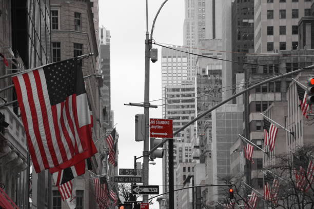 bandeiras dos eua em nova york street - new york city black and white city looking at view - fotografias e filmes do acervo