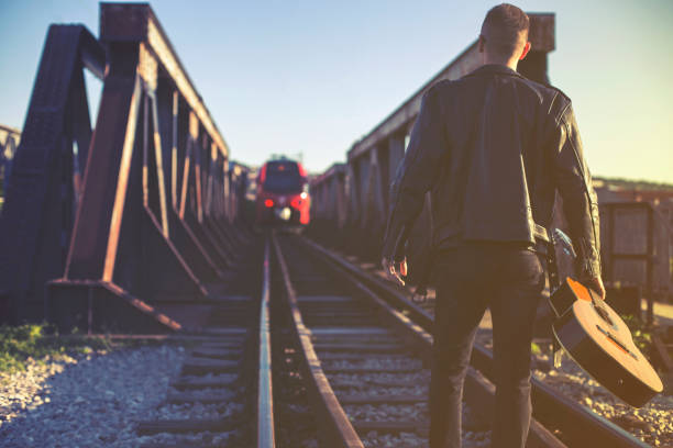 istock Musician with a guitar on the railway 685791774