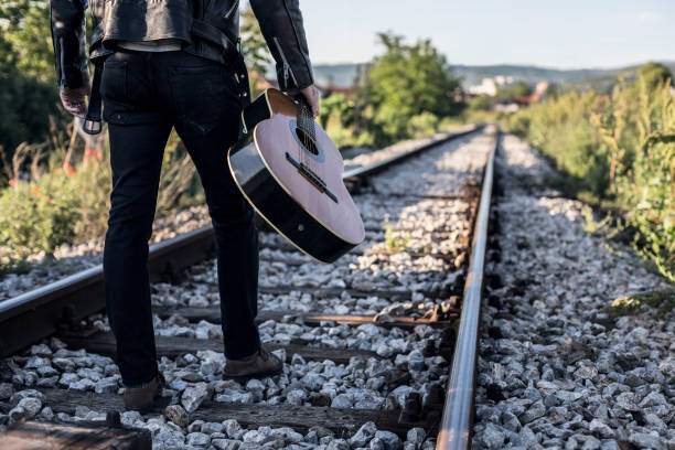 istock Musician with a guitar on the railway 685792498