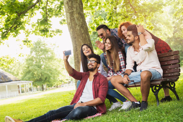 istock Group of young people taking a selfie outdoors on the bench, having fun 685794648