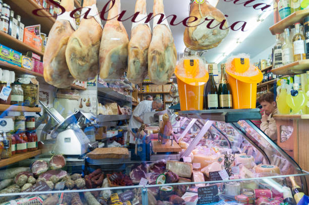 Rome, Italy - April 25, 2014.  A look through the shop window into the butcher shop, F. Ui Ciabatta, Salumeria.  The butcher is serving a customer with many meats displayed in the window.