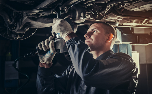 Professional mechanic repairing a car in auto repair shop