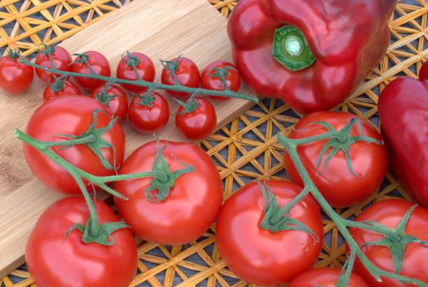 istock Fresh red vegetables, tomatoes and  peppers on a background with a straw mat. 685805948