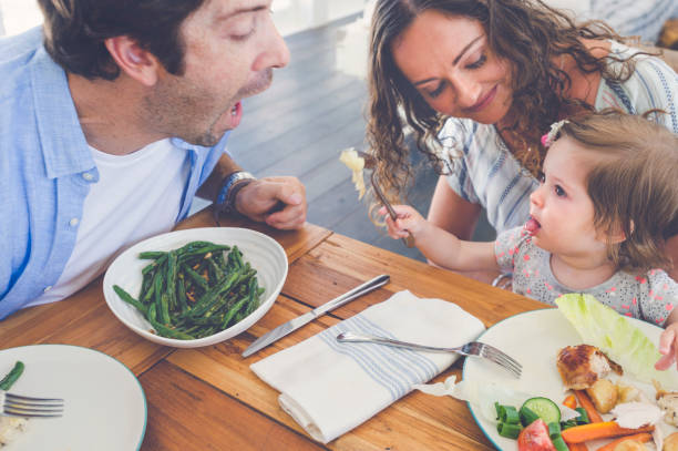 istock Little girl feeding her father. 685808112