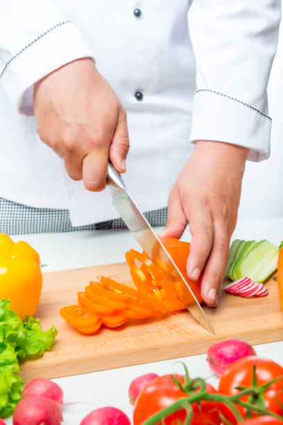 istock Chef cuts the peppers into thin slices on a wooden board close up 685809430