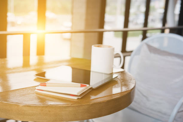 istock pen, notepad, digital tablet and coffee cup on wood table in cafe coffee shop 685809670