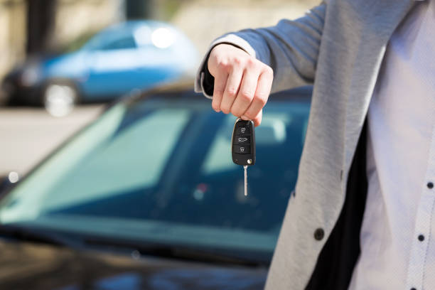 istock Man hand hold the remote control car alarm systems key 685821384