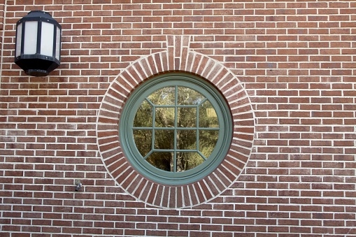 On the side of a building an unusual looking window and brick design