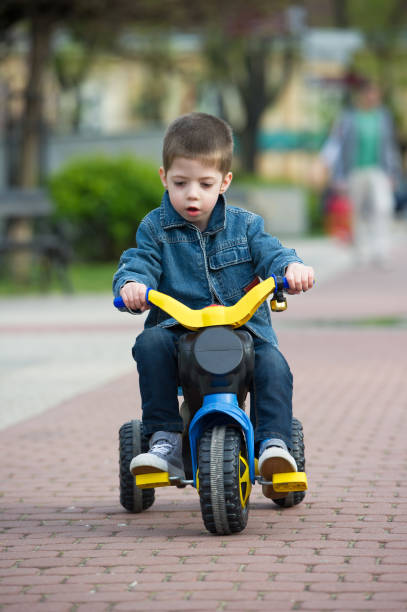 istock little boy ride toy motorcycle on sidewalk 685833200