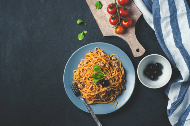 istock Spaghetti with tomatoes in a blue bowl over dark concrete background 685835832
