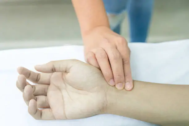Pulse assessment on the pale hand.