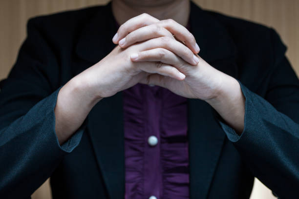 empresária em terno sentado em uma mesa e fecho a mão dela - interview business hands clasped confidence - fotografias e filmes do acervo