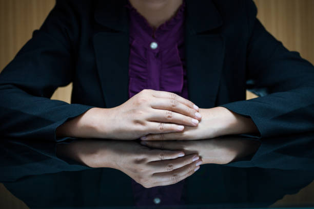 empresária de terno sentada em uma mesa e apertar a mão - interview business hands clasped confidence - fotografias e filmes do acervo