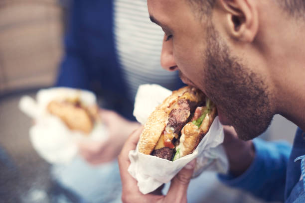 istock Close up of man eating cheeseburger 685842088