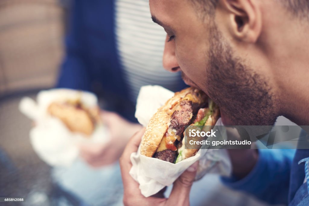 Close up of man eating cheeseburger Eating Stock Photo