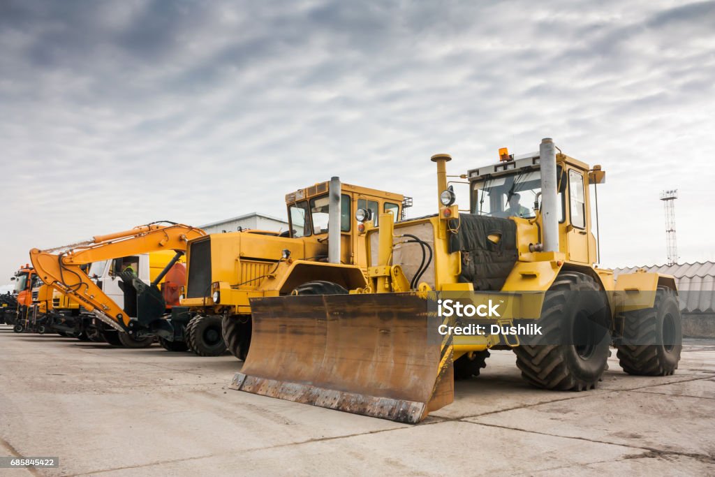 Two heavy wheeled tractor one excavator and other construction machinery Backhoe Stock Photo