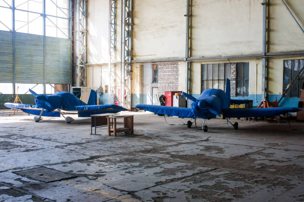 Two shrouded small sports airplanes in a hangar