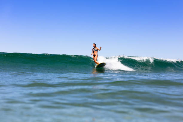 Stylish Surfer Girl Surfing a Malibu stock photo