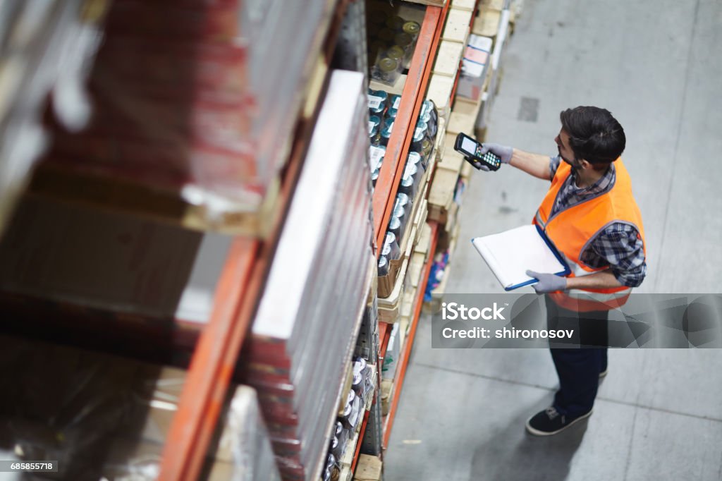Checking barcodes Worker with scanner making review of goods in warehouse Warehouse Stock Photo