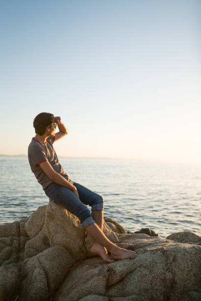 Beautiful young hipster looking at the sea