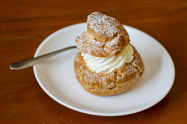 istock Cream puffs filled vanilla custard and dusted with icing on a rack 685861608