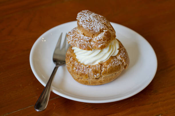 istock Cream puffs filled vanilla custard and dusted with icing on a rack 685861624