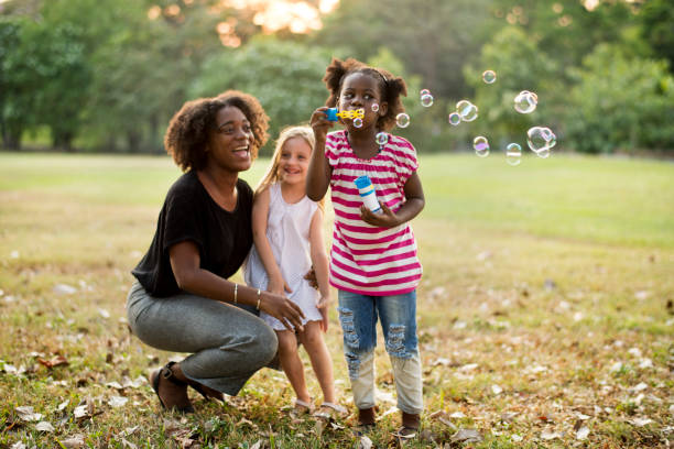 istock Teacher and children in a park blowing bubbles 685863070