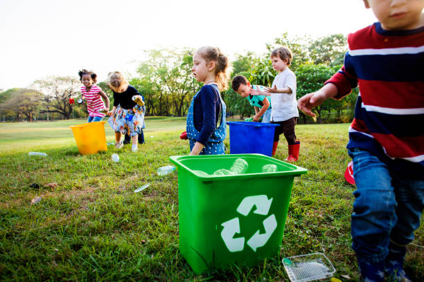 istock Volunteer kids take a trash to recycle bin 685863576