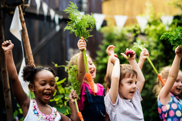 bambini in un orto con carota - child playing multi ethnic group summer foto e immagini stock