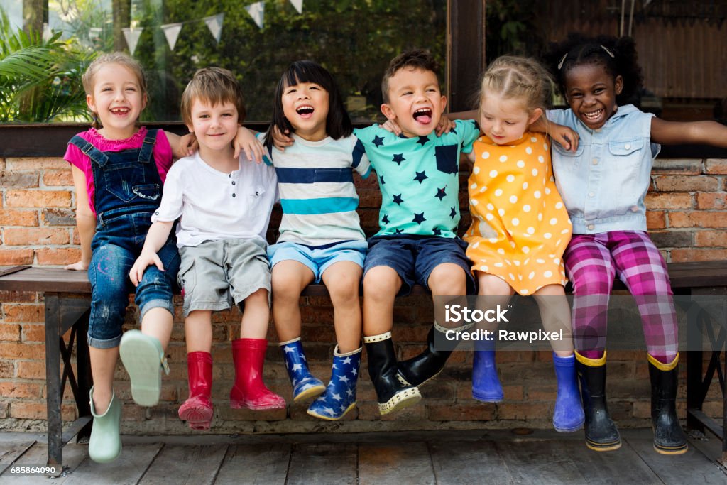 Crianças do jardim de infância amigos braço em torno de sentar sorrindo - Foto de stock de Criança royalty-free