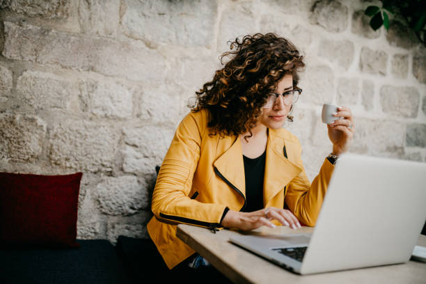 istock Girl drinking coffee and using laptop in the bar 685864640