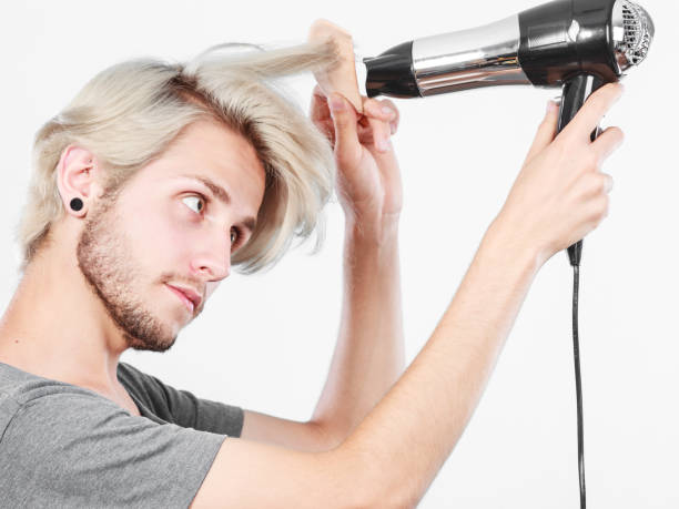 istock Young man drying hair with hairdryer 685864830